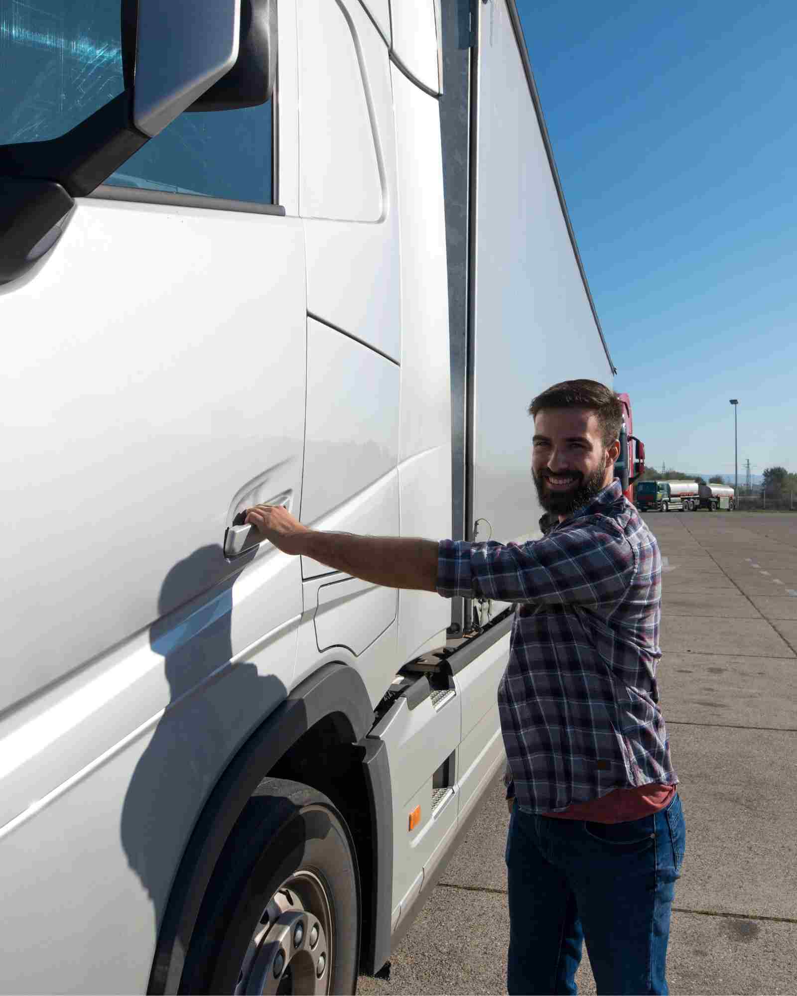 Chauffeur poids lourd à côté de son camion sur une plateforme logistique française
