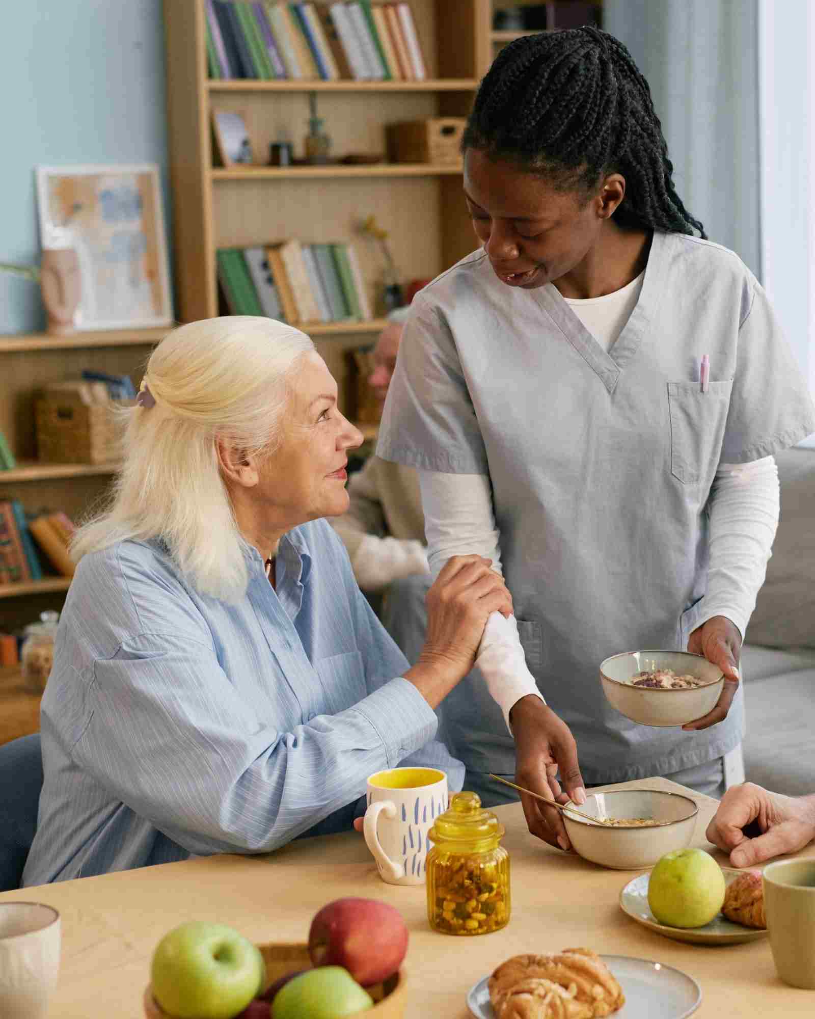 Care assistant supporting an elderly resident in a French nursing home